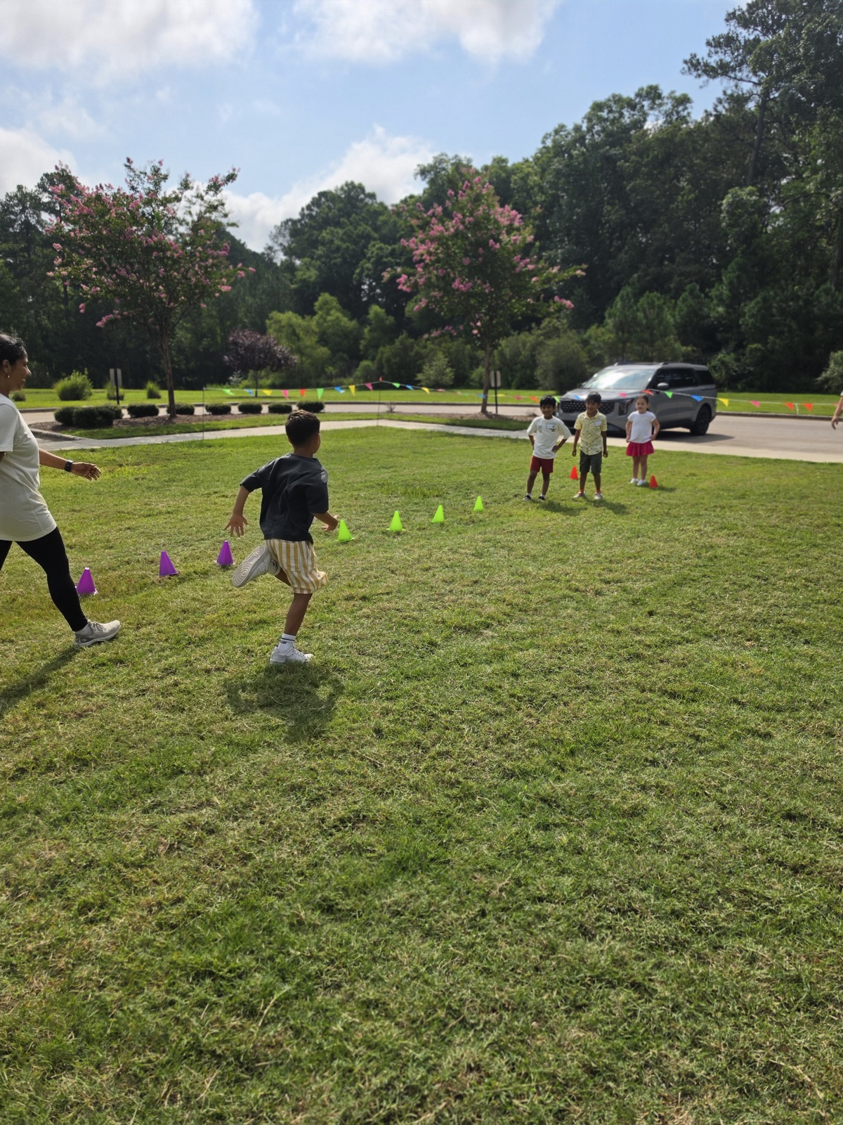 A camper runs toward a group during an outdoor cone game