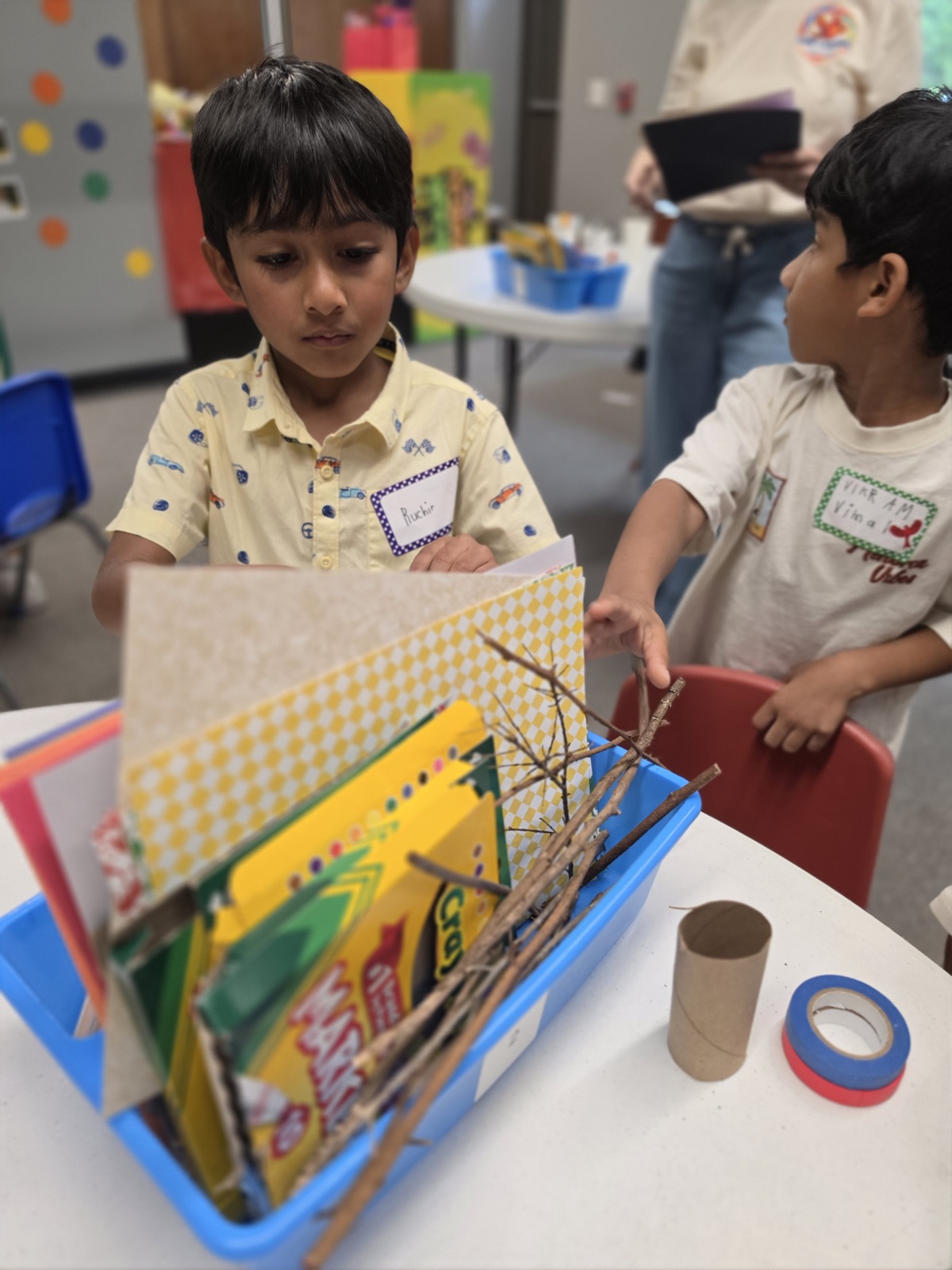 Two campers work together on a nature-themed craft