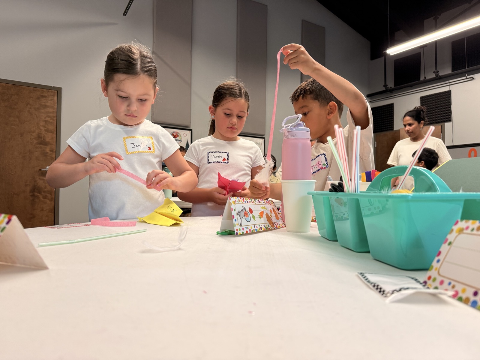 Campers work on colorful paper crafts together at an activity table